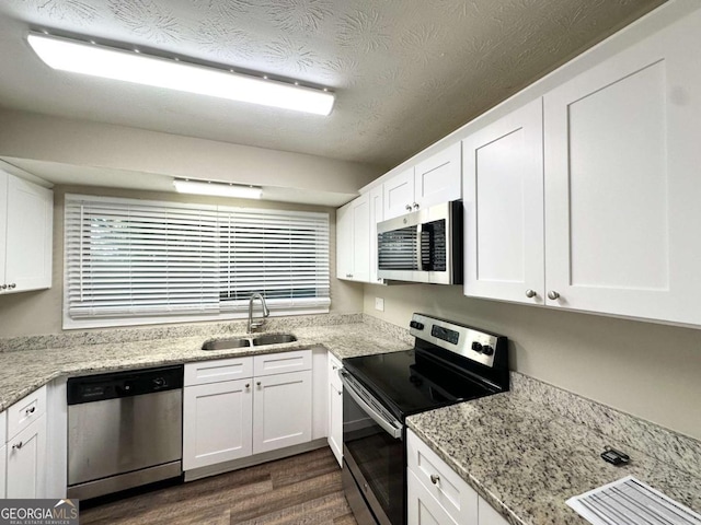 1918 Leigh Dr SW, Conyers, GA 30094 - kitchen featuring appliances with stainless steel finishes, a sink, dark wood-style floors, white cabinets, and light stone countertops