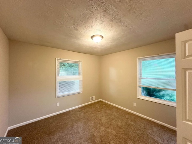 1918 Leigh Dr SW, Conyers, GA 30094 - empty room with a textured ceiling, baseboards, and dark colored carpet