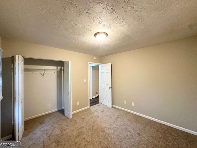 1918 Leigh Dr SW, Conyers, GA 30094 - unfurnished bedroom featuring carpet flooring, a textured ceiling, a closet, and baseboards