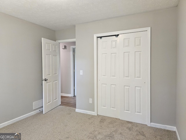 70 Shadow Ln, Carrollton, GA 30117 - unfurnished bedroom with carpet flooring, baseboards, a closet, and a textured ceiling