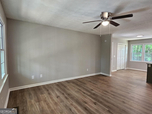 70 Shadow Ln, Carrollton, GA 30117 - spare room with dark wood finished floors, a textured ceiling, a ceiling fan, and baseboards