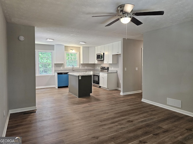 70 Shadow Ln, Carrollton, GA 30117 - kitchen with stainless steel appliances, white cabinets, a textured ceiling, a ceiling fan, and a center island