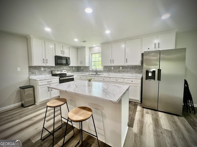 1962 Anderson Rd, Rentz, GA 31075 - kitchen featuring appliances with stainless steel finishes, a sink, wood finished floors, white cabinetry, and recessed lighting