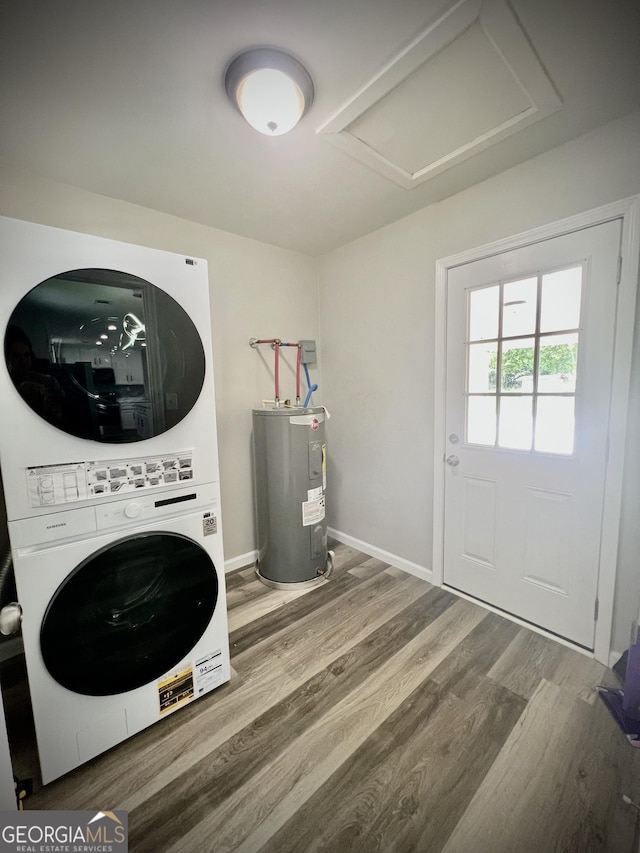 1962 Anderson Rd, Rentz, GA 31075 - laundry area with stacked washing machine and dryer, water heater, wood finished floors, attic access, and baseboards