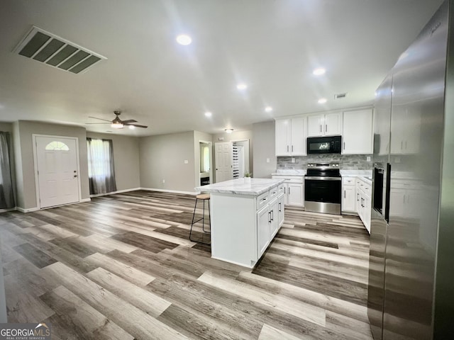 1962 Anderson Rd, Rentz, GA 31075 - kitchen featuring appliances with stainless steel finishes, open floor plan, baseboards, a center island, and light wood-type flooring