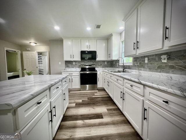 1962 Anderson Rd, Rentz, GA 31075 - kitchen with stainless steel electric stove, a sink, black microwave, white cabinets, and dark wood-style floors