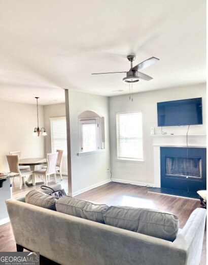 413 Atlas Ct, Locust Grove, GA 30248 - living room featuring a ceiling fan, wood finished floors, baseboards, and a fireplace