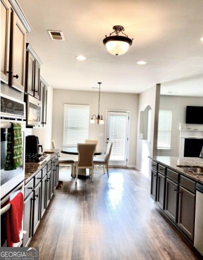 413 Atlas Ct, Locust Grove, GA 30248 - kitchen with stainless steel appliances, dark wood-type flooring, dark stone counters, plenty of natural light, and recessed lighting