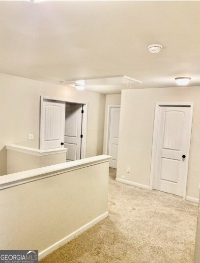413 Atlas Ct, Locust Grove, GA 30248 - corridor with light carpet and baseboards