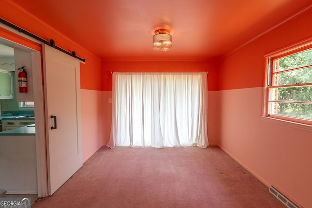 6214 Crestview Dr SE, Covington, GA 30014 - empty room featuring a barn door and light carpet