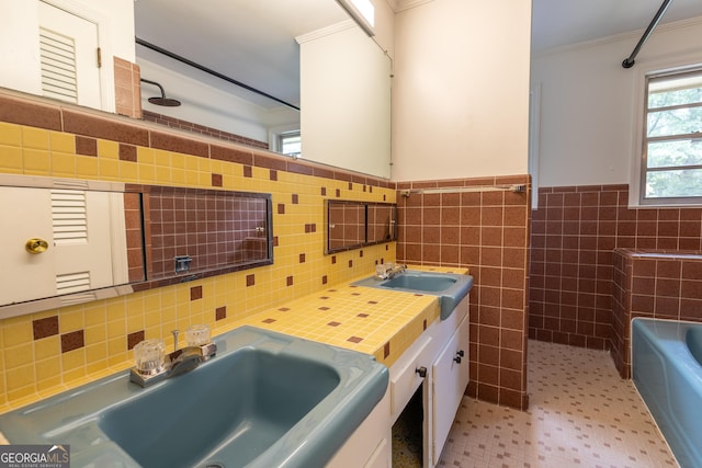 6214 Crestview Dr SE, Covington, GA 30014 - full bathroom with crown molding, a tub to relax in, double vanity, tile walls, and a wainscoted wall