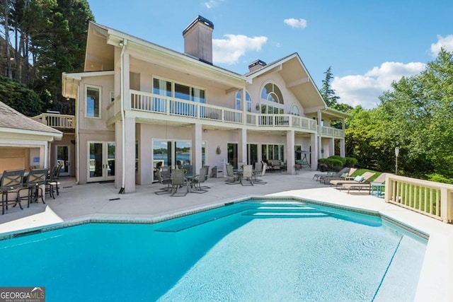 2917 Pointe Dr, Gainesville, GA 30506 - rear view of house with a balcony, a patio area, a chimney, and an outdoor pool