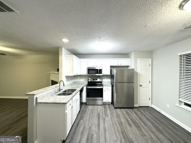 408 Kendall Ln, Mcdonough, GA 30253 - kitchen featuring appliances with stainless steel finishes, a sink, dark wood-style flooring, baseboards, and a textured ceiling