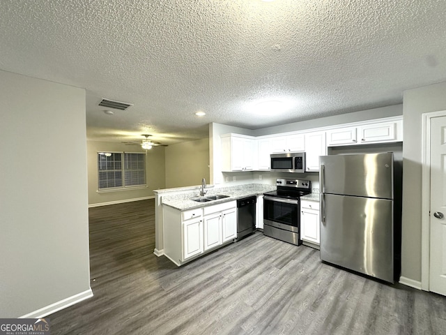 408 Kendall Ln, Mcdonough, GA 30253 - kitchen with stainless steel appliances, a sink, baseboards, dark wood-style flooring, and a textured ceiling