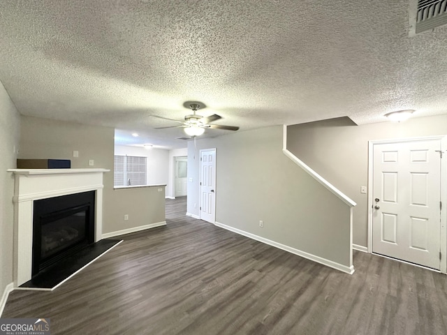 408 Kendall Ln, Mcdonough, GA 30253 - unfurnished living room featuring wood finished floors, a glass covered fireplace, ceiling fan, a textured ceiling, and baseboards