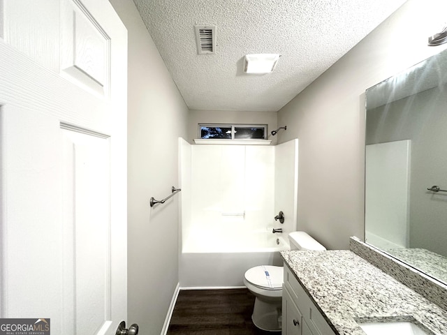 408 Kendall Ln, Mcdonough, GA 30253 - full bathroom featuring toilet, vanity, wood finished floors, a textured ceiling, and  shower combination