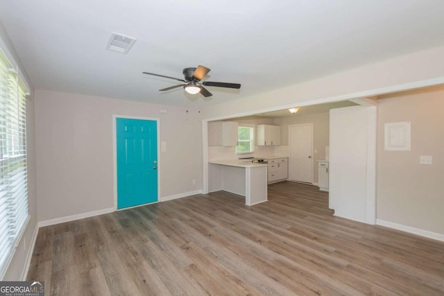 525 Baker Cir NW, Atlanta, GA 30318 - unfurnished living room with wood finished floors, a ceiling fan, and baseboards