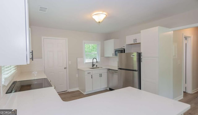 525 Baker Cir NW, Atlanta, GA 30318 - kitchen featuring stainless steel appliances, a sink, tasteful backsplash, light countertops, and white cabinetry