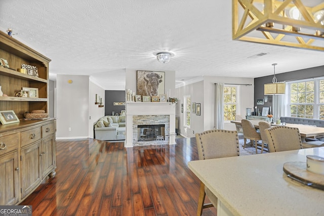 81 Maple Creek Dr, Newnan, GA 30263 - dining space with dark wood-style floors, baseboards, a fireplace, and a textured ceiling
