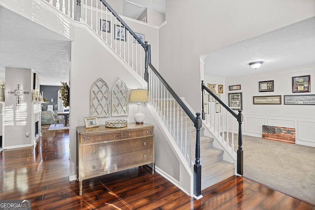 81 Maple Creek Dr, Newnan, GA 30263 - staircase with a towering ceiling, hardwood / wood-style floors, baseboards, and a fireplace