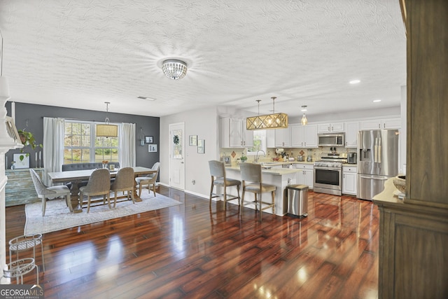 81 Maple Creek Dr, Newnan, GA 30263 - kitchen featuring appliances with stainless steel finishes, light countertops, a peninsula, baseboards, and white cabinets