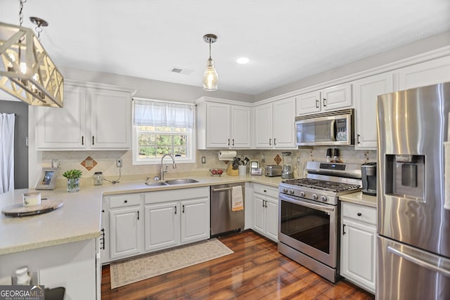 81 Maple Creek Dr, Newnan, GA 30263 - kitchen featuring appliances with stainless steel finishes, a sink, dark wood-style flooring, white cabinetry, and tasteful backsplash