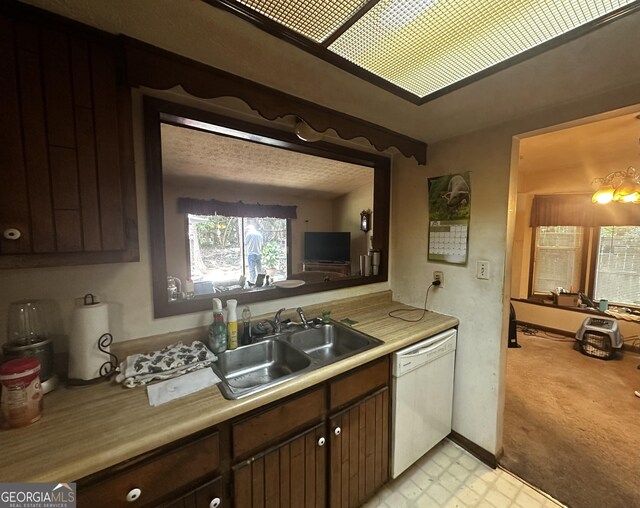 8636 Woodside Ln, Jonesboro, GA 30238 - kitchen with white dishwasher, a sink, light countertops, and light colored carpet