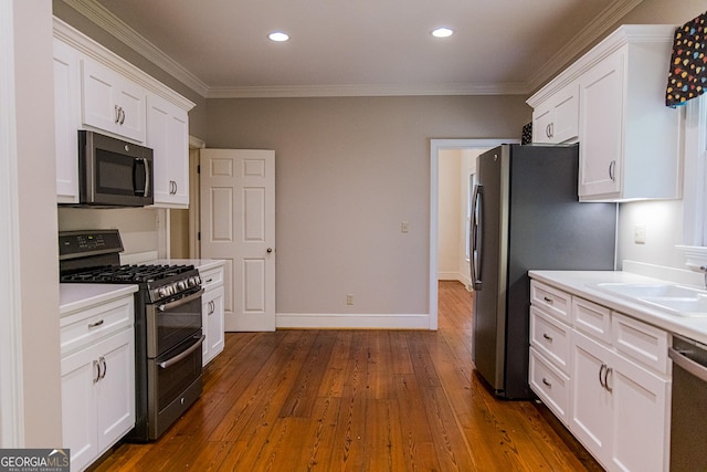 15 Westover Dr SW, Rome, GA 30165 - kitchen featuring appliances with stainless steel finishes, a sink, white cabinetry, dark wood-type flooring, and crown molding