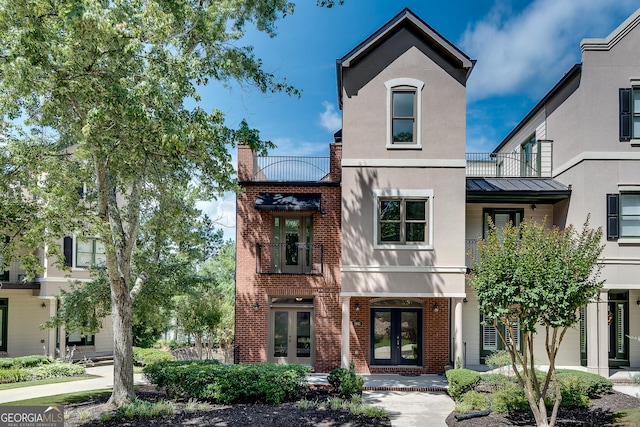 3641 Ridge Towne Dr, Duluth, GA 30096 - view of front facade featuring french doors, a standing seam roof, stucco siding, brick siding, and a metal roof
