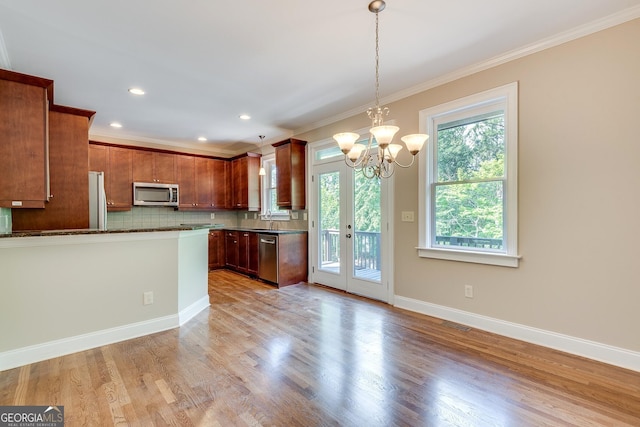 3641 Ridge Towne Dr, Duluth, GA 30096 - kitchen with appliances with stainless steel finishes, ornamental molding, tasteful backsplash, a chandelier, and light wood-style floors