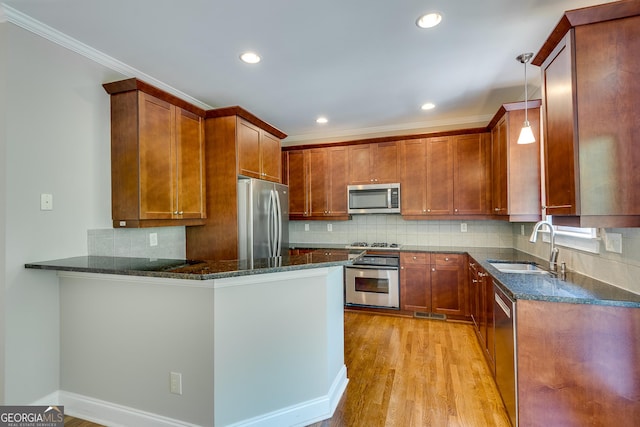 3641 Ridge Towne Dr, Duluth, GA 30096 - kitchen with stainless steel appliances, dark stone counters, a peninsula, light wood-style floors, and crown molding