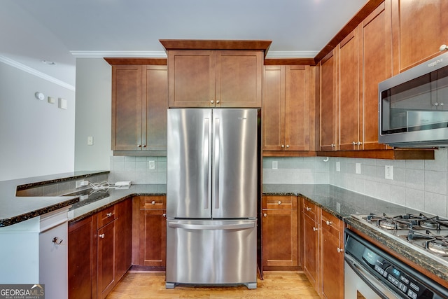 3641 Ridge Towne Dr, Duluth, GA 30096 - kitchen featuring appliances with stainless steel finishes, dark stone counters, crown molding, a peninsula, and light wood-style flooring