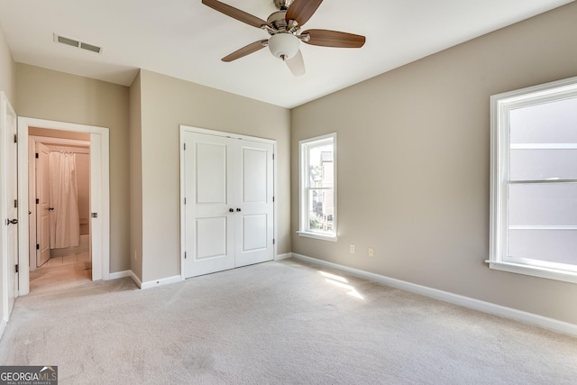 3641 Ridge Towne Dr, Duluth, GA 30096 - unfurnished bedroom featuring light carpet, a closet, multiple windows, and ceiling fan