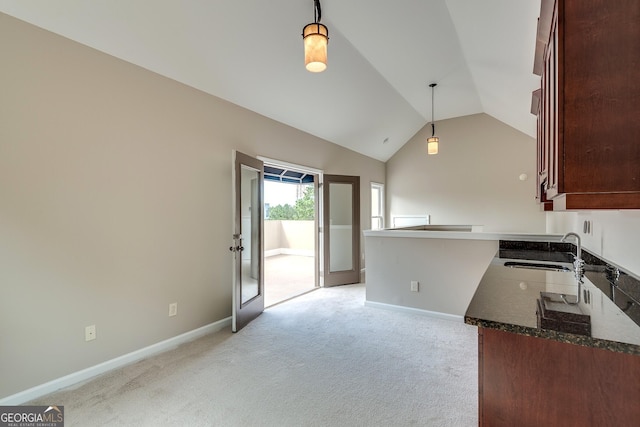 3641 Ridge Towne Dr, Duluth, GA 30096 - kitchen featuring lofted ceiling, pendant lighting, light carpet, dark stone countertops, and a peninsula