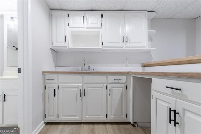 1706 Brandon Lee Way, Marietta, GA 30008 - kitchen with open shelves, light countertops, white cabinetry, light wood finished floors, and a drop ceiling