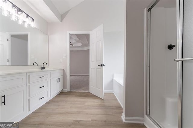 1706 Brandon Lee Way, Marietta, GA 30008 - full bathroom featuring vanity, wood finished floors, a shower stall, a garden tub, and baseboards