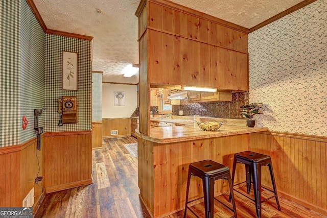 3452 Monica Ln SW, Conyers, GA 30094 - kitchen featuring crown molding, wood finished floors, wainscoting, wallpapered walls, and a textured ceiling