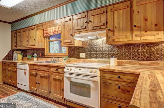 3452 Monica Ln SW, Conyers, GA 30094 - kitchen featuring white appliances, under cabinet range hood, a sink, crown molding, and light countertops