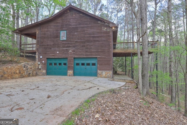 3452 Monica Ln SW, Conyers, GA 30094 - view of side of home featuring driveway, a garage, a wooden deck, and stone siding