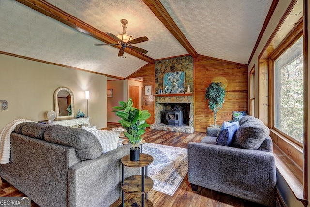 3452 Monica Ln SW, Conyers, GA 30094 - living area with wood walls, a ceiling fan, a textured ceiling, wood finished floors, and a fireplace