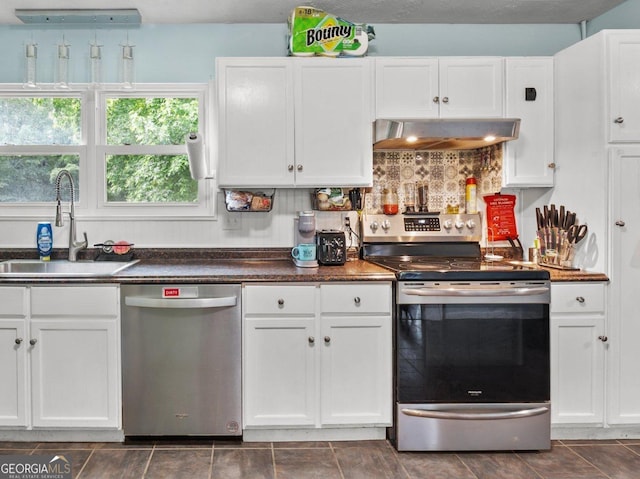 1 Donley Dr NW, Rome, GA 30165 - kitchen featuring appliances with stainless steel finishes, range hood, a sink, white cabinetry, and dark countertops
