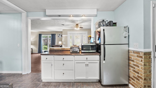 1 Donley Dr NW, Rome, GA 30165 - kitchen with stainless steel appliances, white cabinetry, a ceiling fan, a peninsula, and dark stone countertops