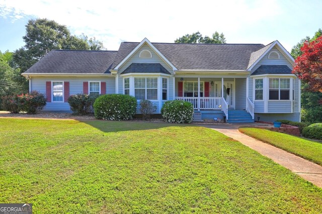221 Ashley Trace Dr, Locust Grove, GA 30248 - view of front facade with a porch, a front lawn, and a shingled roof