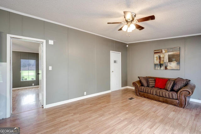 4040 US Highway 25 N, Hephzibah, GA 30815 - living room featuring ceiling fan, a decorative wall, wood finished floors, crown molding, and a textured ceiling