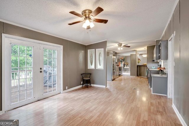 4040 US Highway 25 N, Hephzibah, GA 30815 - unfurnished living room featuring a ceiling fan, light wood-style floors, crown molding, a textured ceiling, and french doors