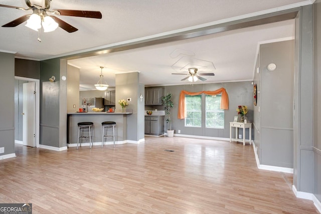 4040 US Highway 25 N, Hephzibah, GA 30815 - unfurnished living room featuring a ceiling fan, light wood finished floors, ornamental molding, and baseboards