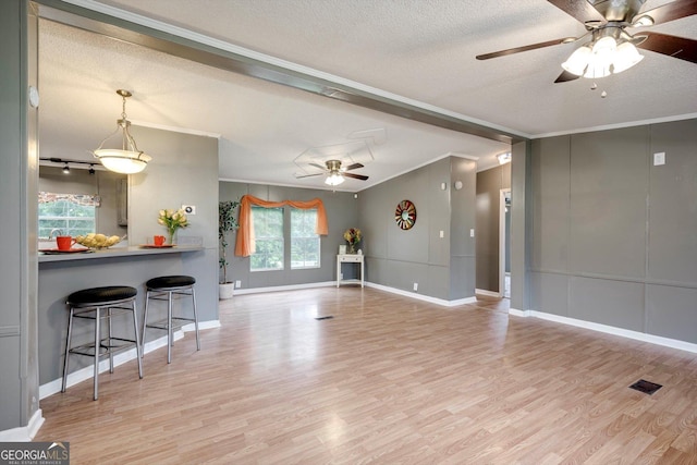4040 US Highway 25 N, Hephzibah, GA 30815 - unfurnished living room with a ceiling fan, ornamental molding, wood finished floors, baseboards, and a textured ceiling