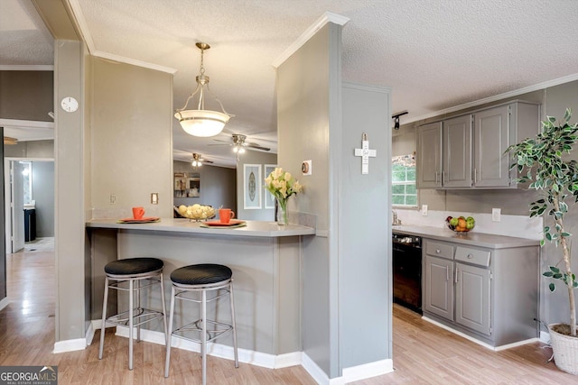 4040 US Highway 25 N, Hephzibah, GA 30815 - kitchen featuring gray cabinets, black dishwasher, ceiling fan, a breakfast bar area, and light wood-style floors