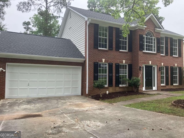 7593 Watson Bay Ct, Stone Mountain, GA 30087 - colonial home featuring concrete driveway, brick siding, a garage, and roof with shingles