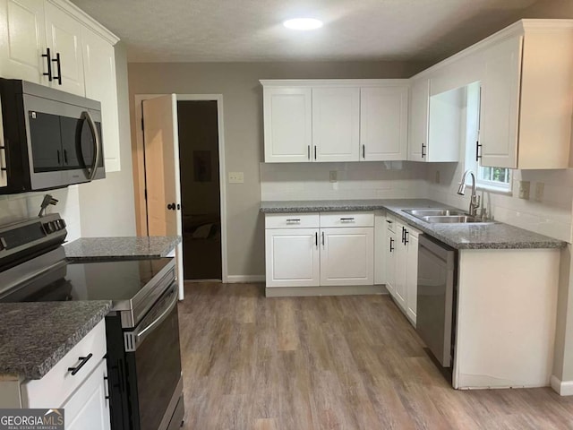 7593 Watson Bay Ct, Stone Mountain, GA 30087 - kitchen featuring appliances with stainless steel finishes, decorative backsplash, white cabinetry, and light wood-type flooring